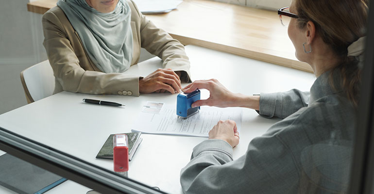 FPI Top 10 | woman stamping a visa