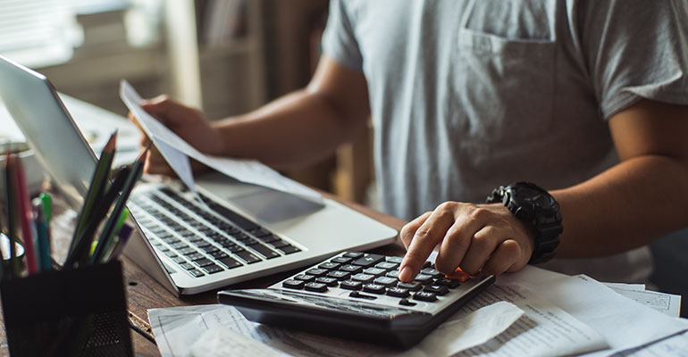 FPI Top 10 | Man at a desk typing on calculator