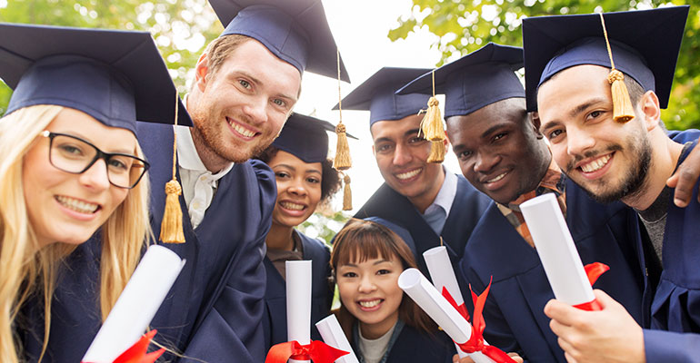 FPI Top 10 | Graduates huddled together in cap and gown looking at the camera