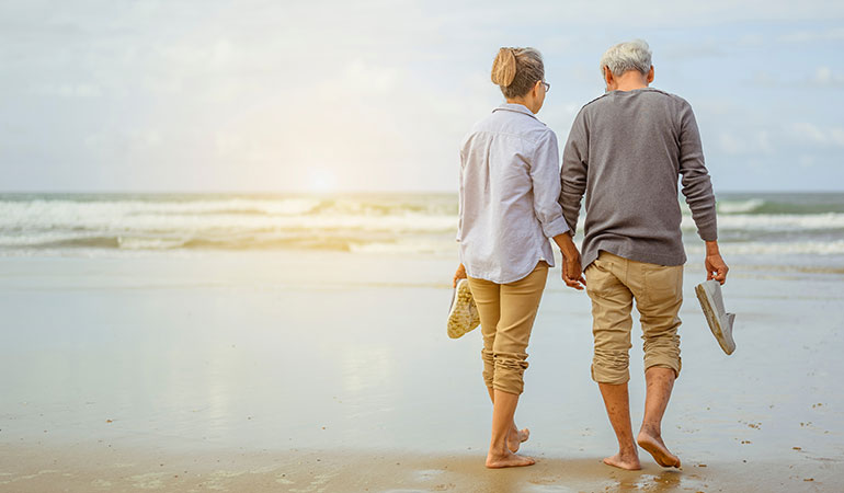 Retired couple walking on a beach