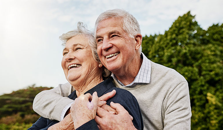Retired couple hugging closely